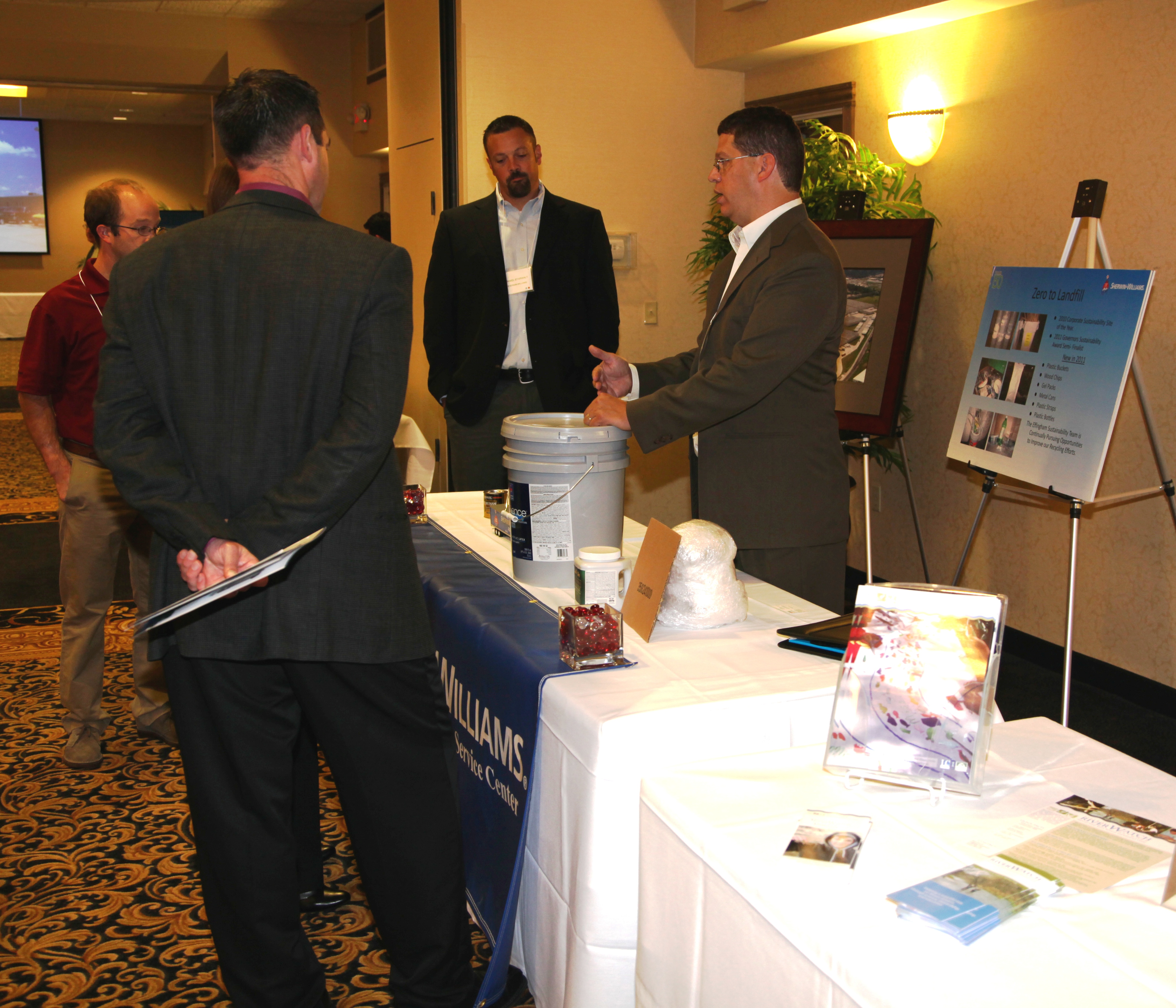 An exhibitor discusses his display with other participants An exhibitor discusses his display with other participants