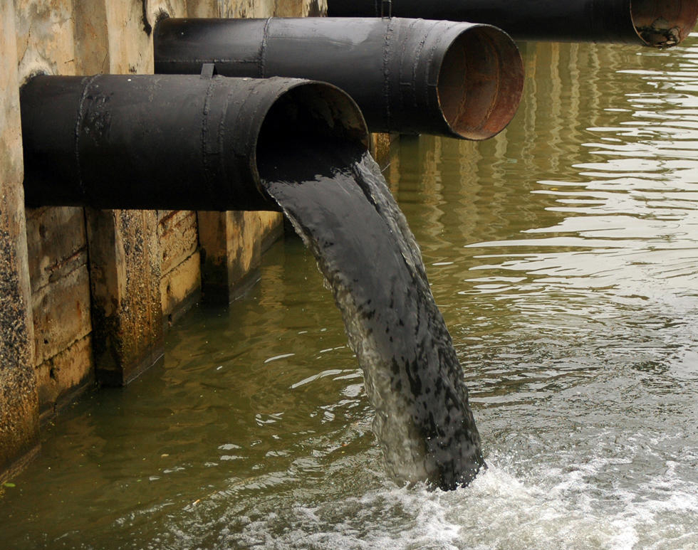 dirty black water flowing into an industial cannal