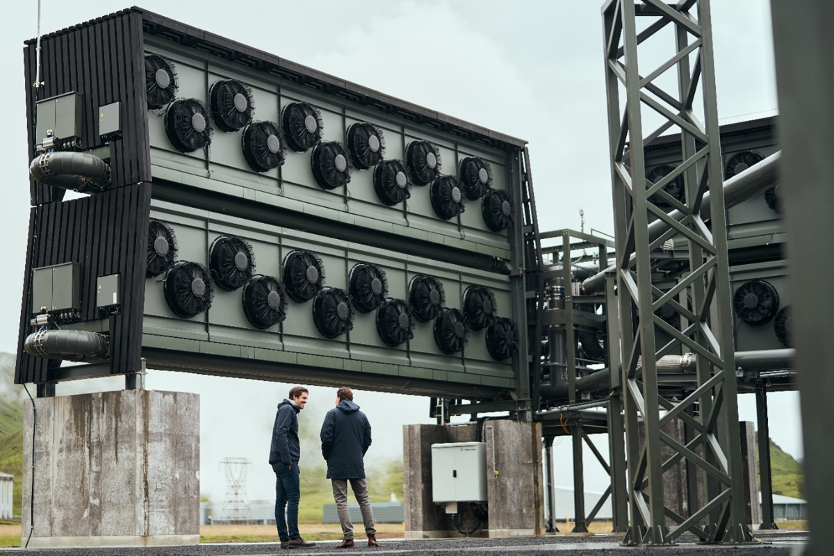 direct air capture equipment. outside with two huge gray metal boxes stacked on top of each other with 12 air intake fans each and big pipes leading gas separators
