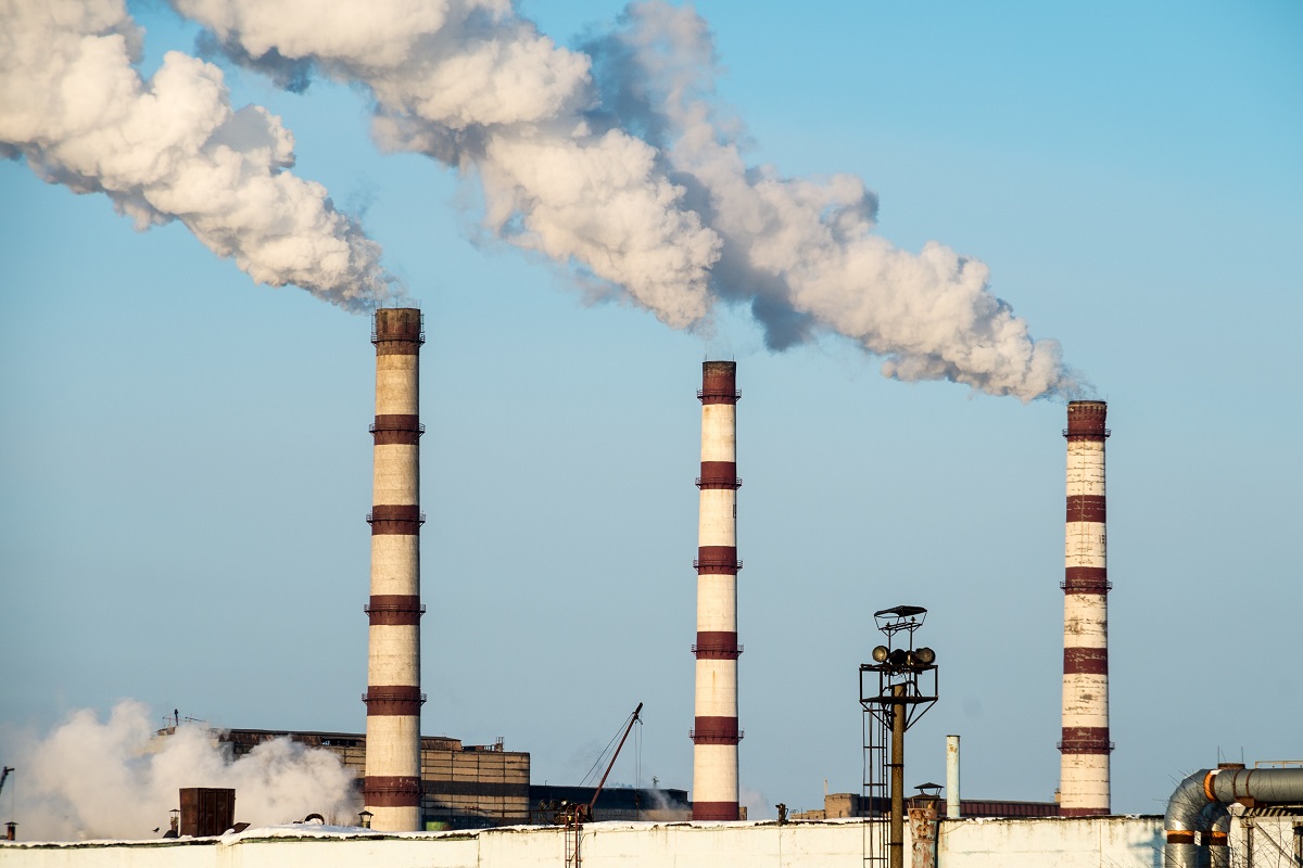 coal fire power plant featuring emissions stacks at top of building