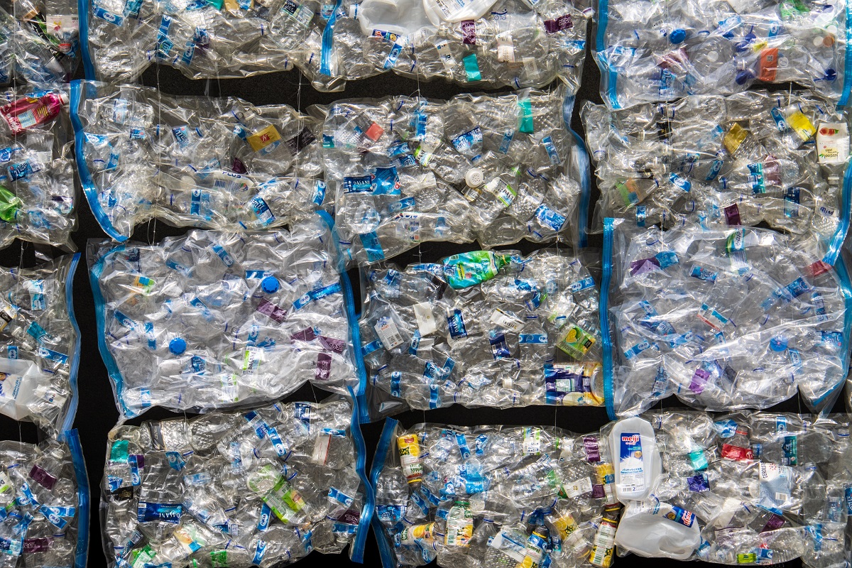 all types of plastics are squished together in big square bales. several bales are stacked up.